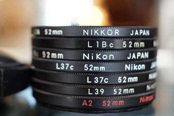 Lot of 8 Nikon filters + Screw in lenshood 52mm