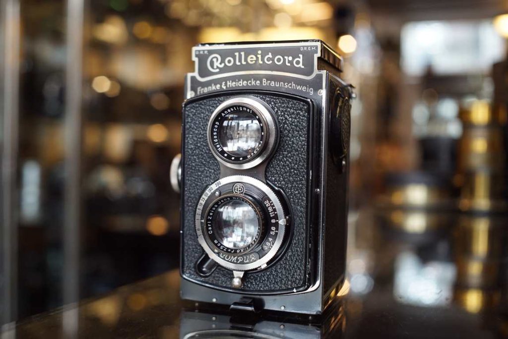 Early Rolleicord sold as collectors itrem. Beautiful classic camera design with nice fonts, nice chrome and nickel accents and simplistic layout. Some normal age related wear but for a camera that is almost 100 years old it is in super good condition. The shutter fires, although it sounds a bit sluggish on the slow speeds. Might be usuable with film but not machine or film tested. Nice optics with only a light layer of haze inside. Good healthy leather covers with some light marks here and there. Finder a bit dusty. Sold as decorative piece, no warranty.