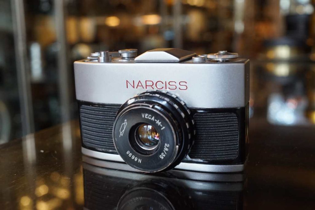 This Narciss is a export version with latin font engravings. It shoots 16mm film respooled into small cartridges which one is included in the camera (no film inside). The camera looks very nice with just some paint wear on the back door. The camera actually fires and speeds sound accurate but werent tested for accuracy. The optics look good and focus also turns smooth although a bit on the heavy side. Aperture works correctly too. We sell this camera as a collectors piece and would definitely fit well into a miniature camera collection. No warranty on functionality due to collectible nature.