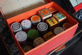 Red Leica box filled with 15 vintage war-time film boxes and cannisters