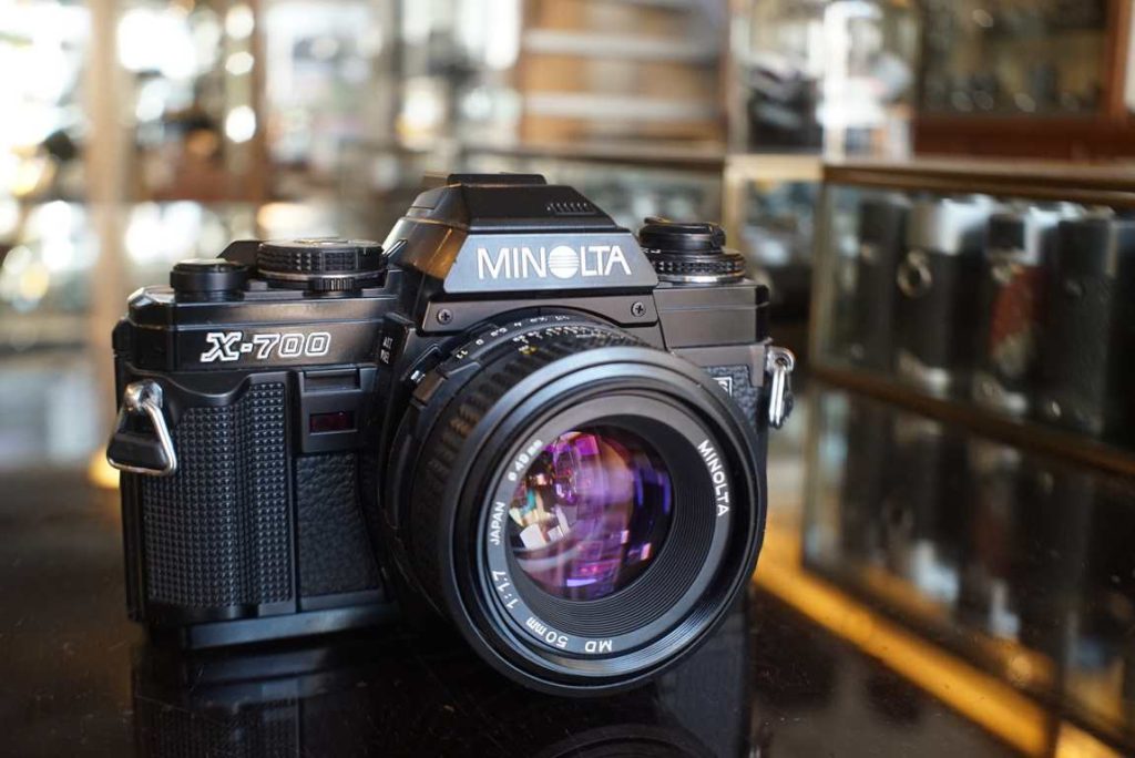 This Minolta X700 with matching MD 50mm f/1.7 lens comes in excellent condition with just some light wear. Clear finder with nice split prism focusing spot. The camera was checked on our testequipment and passed all tests with flying colours. Both the meter and shutter are spot on. The MD 50mm f/1.7 has smooth focus and a correct working aperture. Optics are in excellent shape. Nice kit for the starter but for more advanced user as well
