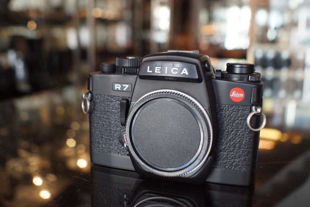 A beautiful condition Leica R7 in terms of cosmetics. Minimal signs of use. In terms of mechanics it has some positive and negative remarks: The mirror mechanism recently was serviced, the mirror damper can be quite slow on these R models, this issue has been resolved and the full mechanism was cleaned and adjusted. This mirror and shutter action now works as intended again. The downside of this camera is that there is a fault in the mode selector dail, this camera stays on P mode. The selector can be turned to M mode for example, but it will always select its own shutter speeds. Not really a problem for beginners, but more advanced shooters who like to choose their own speeds can not do this. The light meter is perfect so the P mode will select good exposures every time, all speeds are machine tested and in tolerance. Dail might be repairable, but our technician does not have the replacement part for this. Good seals. Clean viewfinder. Because of the mode dail issue, this camera comes without warranty.this item comes without warranty, but it can be returned in 14 days after delivery