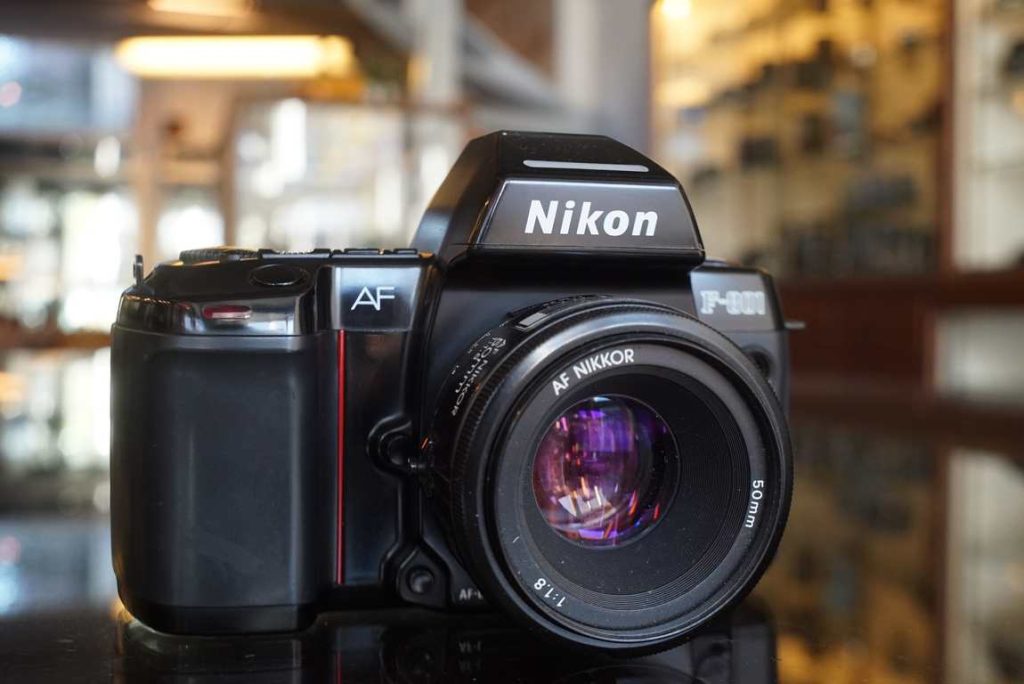 Rather nice looking Nikon F801 SLR with matching 50mm F/1.8 Nikkor lens. The 801 was a camera aimed at prosumers who liked to have automated functions and autofocus. The system offers very reliable and reasonable quick AF on its single point in the center of the finder. The camera can be set on fully auto, semi auto or fully manual exposure modes. All settings are shown on its large top LCD near the command dails and buttons. The fitted Nikkor 50/1.8 AF lens has good optics and fast AF. All the shutter speeds and light meter readings are spot on when testing them on our machines. Some normal usermarks around but overall a great looking 80s design SLR. Some scrathes on the left side of the prism housing. Takes 4x AA batteries which makes it bit heavy but offers so much in return if you don't mind the weight.this item comes with a 3 month limited warranty