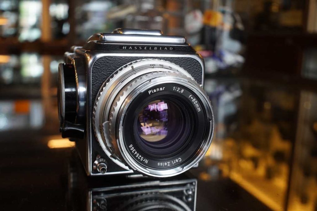 The classic Hasselblad kit: a 500C in chrome with matching chrome 80mm F/2.8 lens and A12 magazine. The kit was fully serviced by ACR, a big operation which resulted in a perfect working kit again. The back received new seals and lubrications, the body was serviced and the lens' aperture and shutter were disassembled, cleaned and adjusted as well. Not only does this kit work as new again, considered its age looks very good still. Some light faded markings on the lens scale but still perfectly readable. Focus is smooth, setting the aperture has good clicks. Standard focusing screen. Winding feels smooth, WLF opens and closes as intended. Back has good seals and spacing. The film memo holder on the back is a bit loose sometimes but most people don't use this anyway. True iconic camera ready for its new owner and many decades of use again.this item comes with a 3 month limited warranty