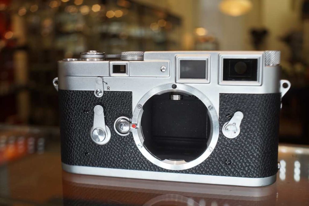 Leica M3 single stroke made in 1959, still with buddha lugs. The camera received a fresh CLA from ACR where the camera got fully disassembled and cleaned and lubricated and the shutter and rangefinder was also cleaned and lubricated including the frameline mask. The rangefinder patch is nice and bright and has no seperation. The shutter is accurate on all speeds again. The rangefinder is correctly aligned. The body also got new covering as the vulcanite had crumbled badly. Cosmetically the camera is in good shape aside from a small dent near the counter mechanism but this does not harm function at all. A lovely Leica M3 ready to be used again. Comes with one flash sync cover and a PC sync cable adapter installed in the electronic flash socket.this item comes with a 6 month limited warranty