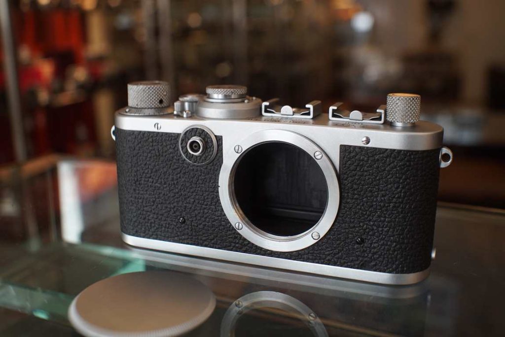 Leica 1f system camera in great collectors shape. The camera only shows minimal signs of use and does not have deep scratches in the body panels, even the bottom plate looks very clean and neat. There is no missing pieces of vulcanite. The bottom covers comes off and on as inteneded. Winding feels ok. The shutter does fire at all speeds but has not been tested for accuracy, since we already see it dragging a bit on most speeds. This camera sat unused for a long time, it was part of a big Leica collection and originally had a 28mm F/5.6 on it. The perfect lens for a camera like this since there is no rangefinder or viewfinder. often used in hip fire setups or in scientific applications or with visoflex. The curtain of this camera has some cracks, we are not sure if its leaks, but we recommend a full CLA and curtain replacement if you are planning on really using the camera. Sold as-is without warranty for the collector in current shape.OUTLET products are not tested extensively and are not cleaned to perfection. They come as-is without any warranty.